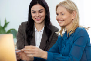 Duas mulheres realizando o seu planejamento financeiro na frente de um computador